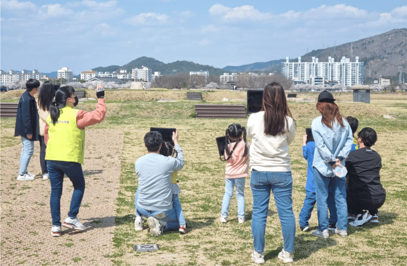 태블릿PC를 활용하여 증강현실 황룡사를 체험하는 사람들
