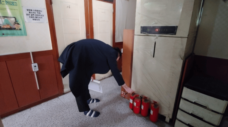 고시원 내 소화기 압력을 점검 중인 구청 직원